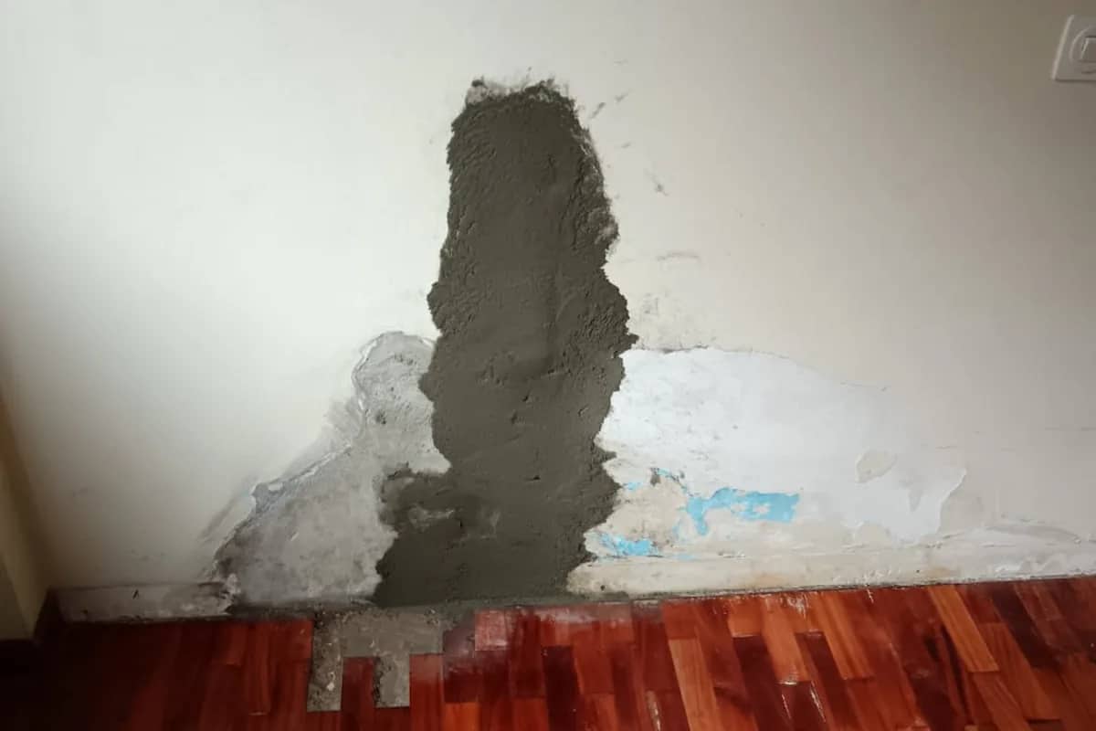 Roza reparada con mortero en la base de una pared tras localizar la humedad